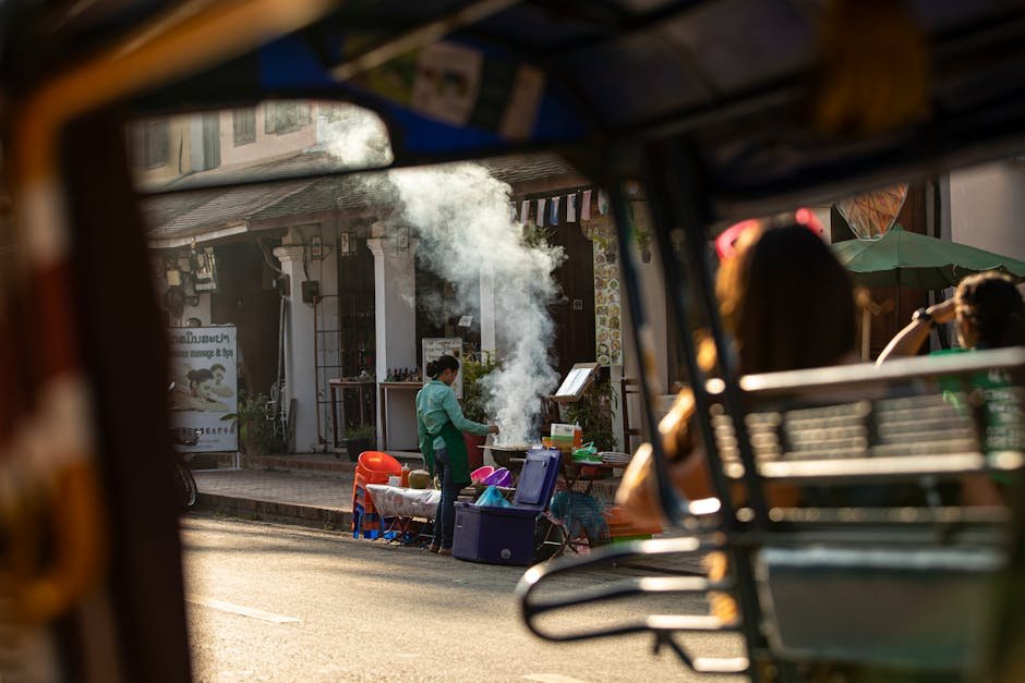 馬來西亞生活費：Street vendor cooking food on a busy Southeast Asian street,