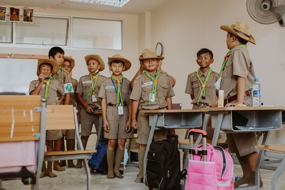 馬來西亞 國際學校 回台：Boy scouts in uniform having fun in a classroom, showcasing