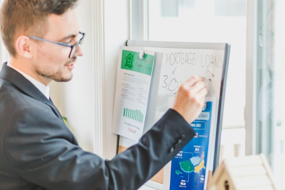 馬來西亞 外國人 房貸：Businessman in suit writes on whiteboard displaying mortgage