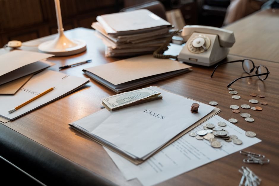 馬來西亞 稅務 居民：Close-up of an office desk with tax documents, coins, glasse