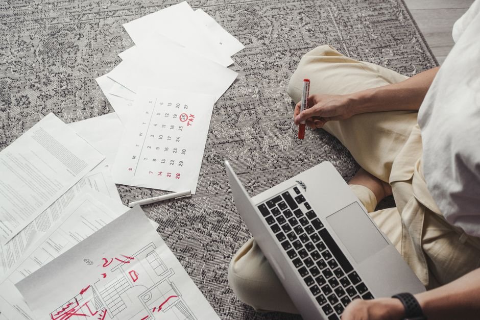 MM2H 申請 流程：Young man working on plans with laptop and calendar, organiz